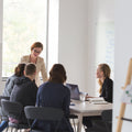 Group of people in a meeting around a table in an office setting.