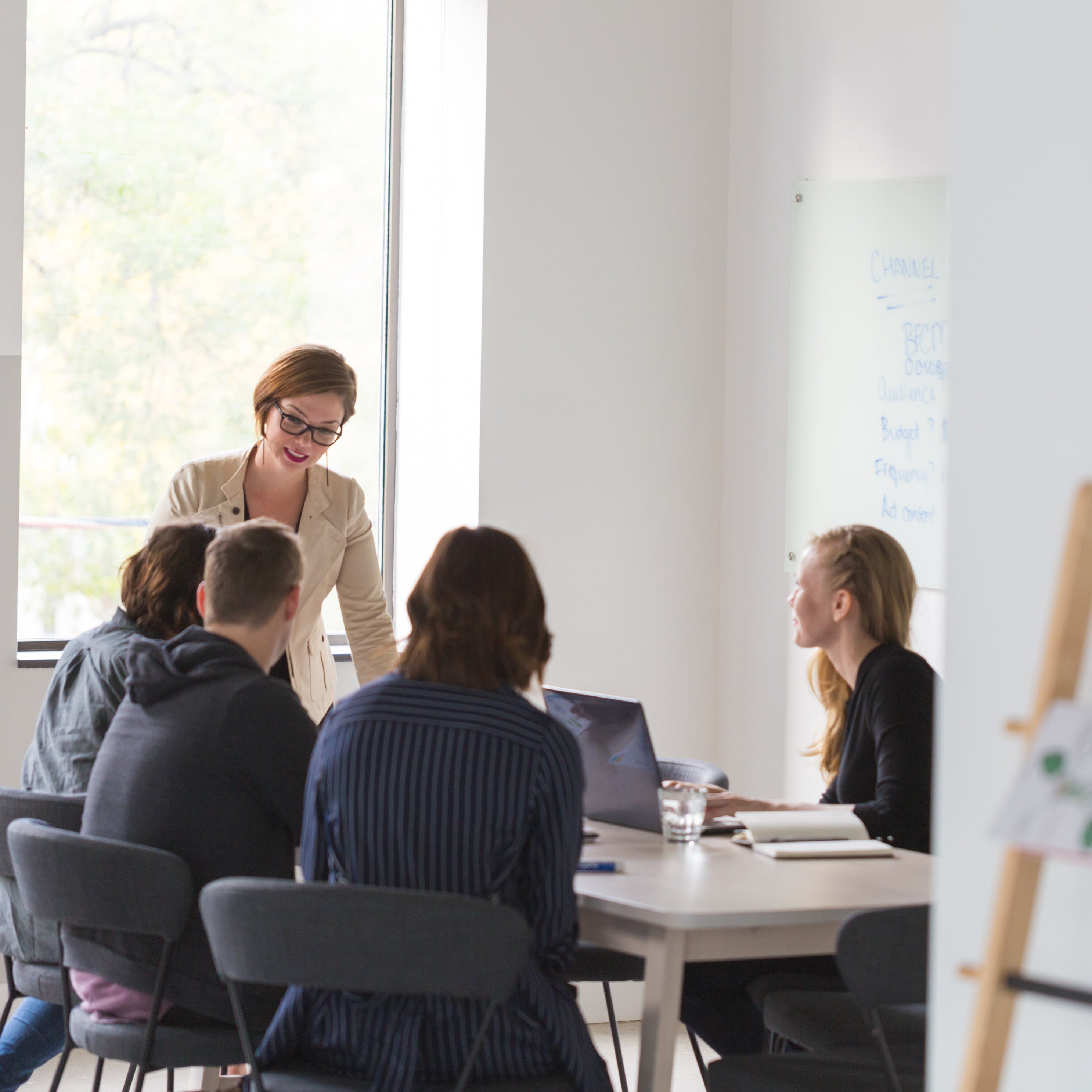 Group of people in a meeting around a table in an office setting.